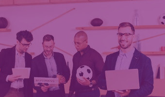 Sportmarketing Geschäftsleute besprechen sich mit Fußball und Laptop in der Hand