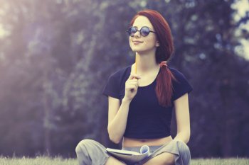 Studentin sitzt auf einer Wiese und lernt