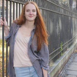 Schueler fragen 9 Eine Studentin lehnt an einem Zaun.